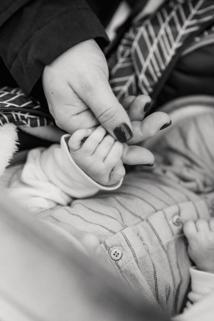 Baby sleeping in bed and holding hand